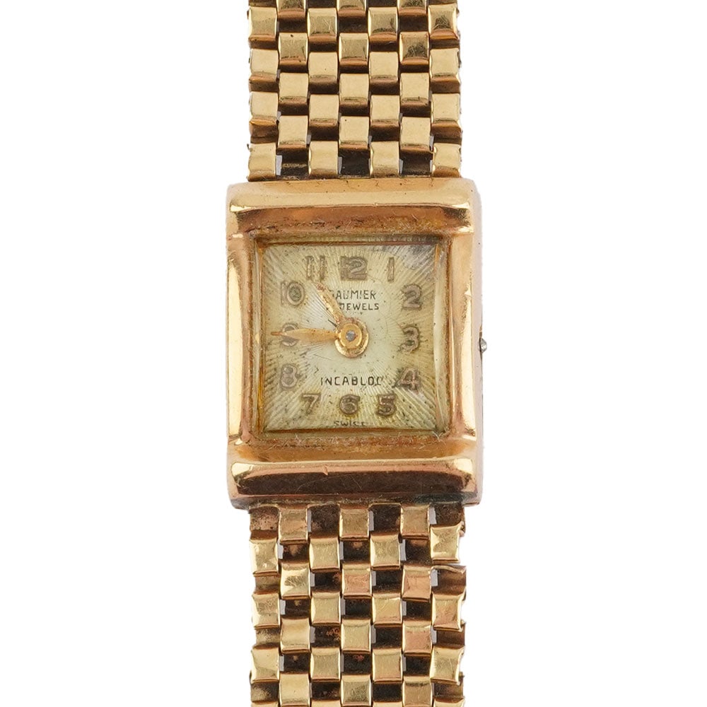/ 14K GOLD -: Description française: MONTRE / 14K GOLD Montre-bracelet Daumier en or 14K, boîtier de 1.9 x 1.4 cm, cadran champagne. Chiffres arabes appliqués pour les heures. Poids brut: 23.2 g