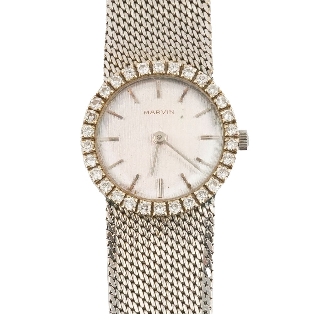 MARVIN / 14K GOLD: Description française: MARVIN / 14K GOLD Montre-bracelet en or blanc 14K, boîtier de 24 mm, cadran argenté, lunette sertie de diamants, index appliqués pour les heures, mouvement m