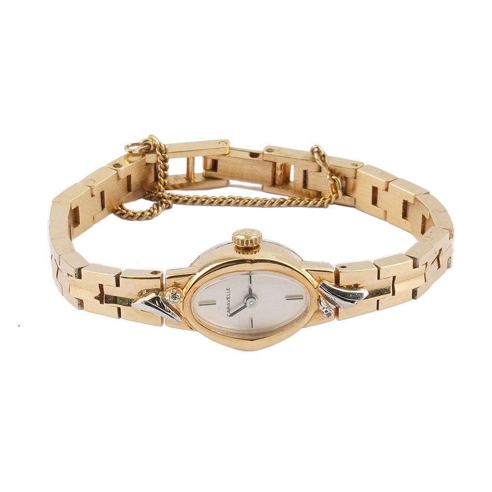 CARAVELLE: Description française: CARAVELLE Montre-bracelet Caravelle en métal doré, boîtier ovale de 1.6 x 1.4 cm, cadran blanc, index pappliqués pour les heures, mouvement