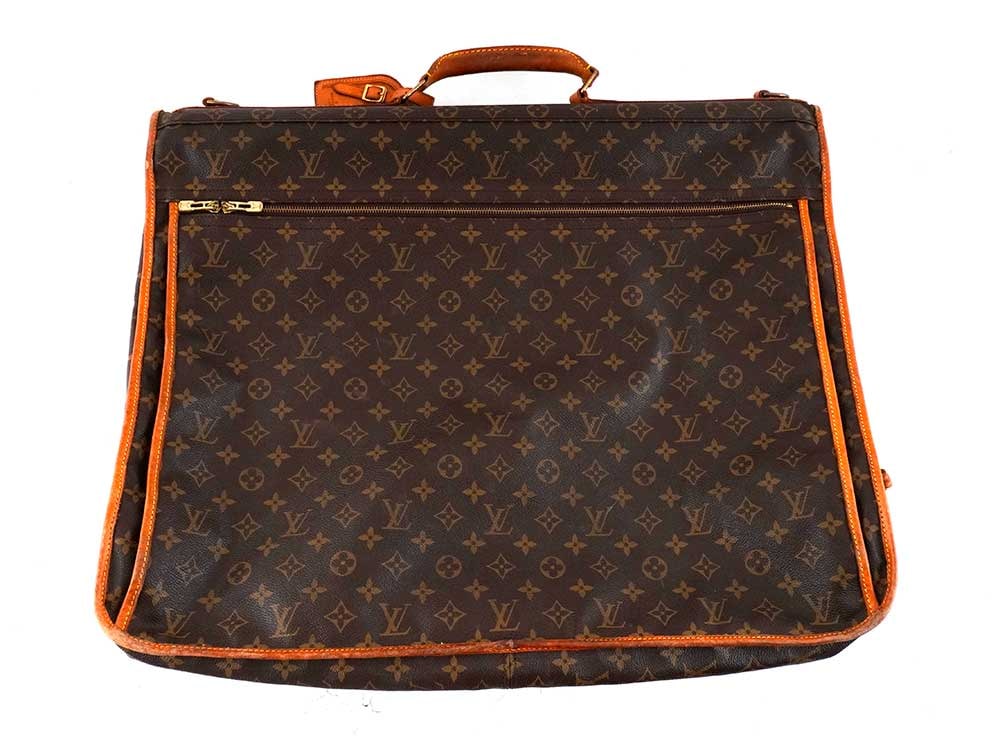 LOUIS VUITTON: Description française: LOUIS VUITTON Sac de voyage Louis Vuitton à vêtements en toile enduite Monogram et cuir naturel. H: 50 cm - 20", L: 60 cm - 23.75", P: 8 cm - 3" English