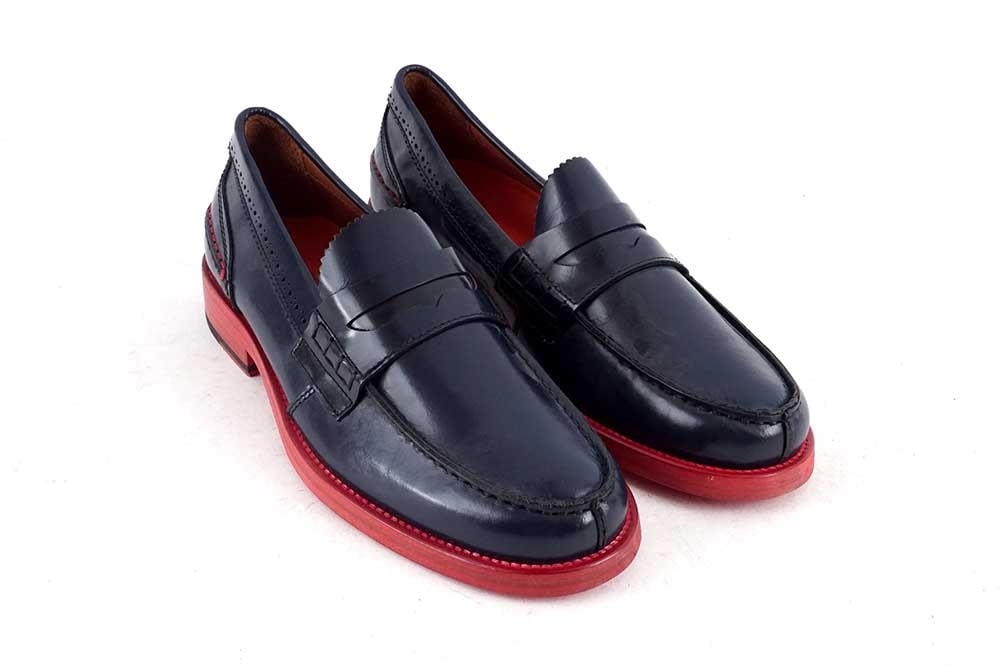 TOMMY HILFIGER: Description française: TOMMY HILFIGER Mocassins à bride de cuir bleu et semelle contrastante rouge. Taille 42 English Description: TOMMY HILFIGER Blue leather penny loafers with a