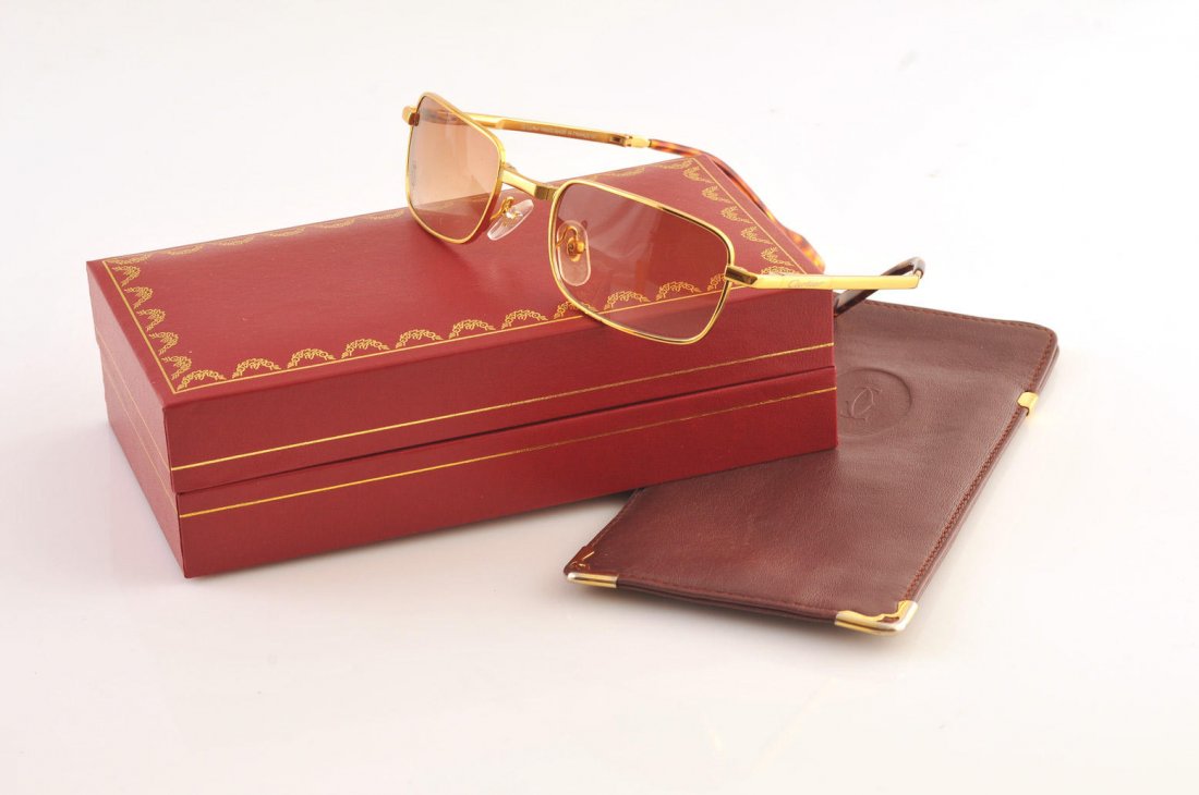 CARTIER: Folding sunglasses. With its burgundy leather case and box. Signed ‘’Cartier Paris’’.