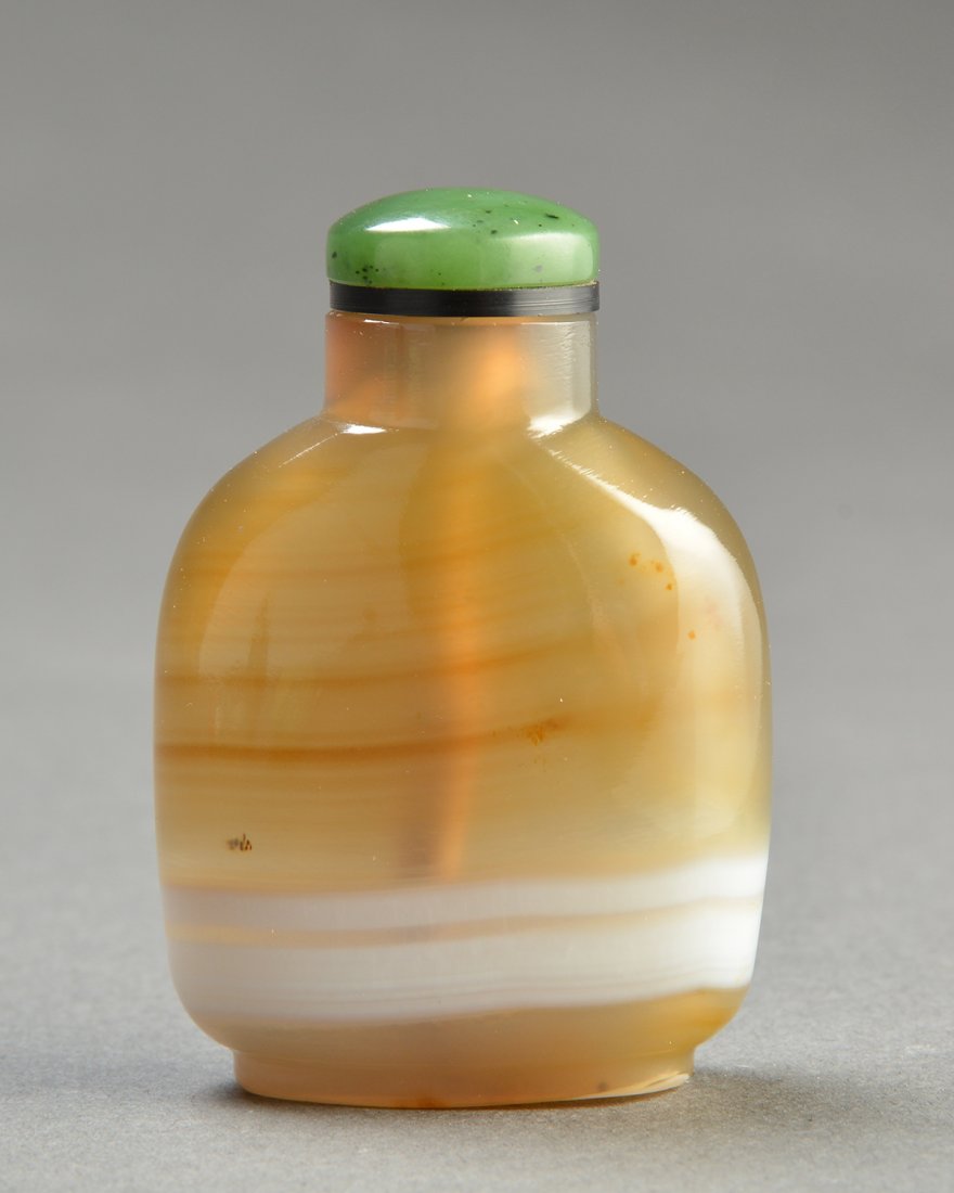 BANDED AGATE SNUFF BOTTLE: BANDED CHALCEDONY AGATE SNUFF BOTTLE, of warm honey-brown color with white veining above the foot. China, QING DYNASTY. Stopper. H: 5cm - 2" E : 50 / 100
