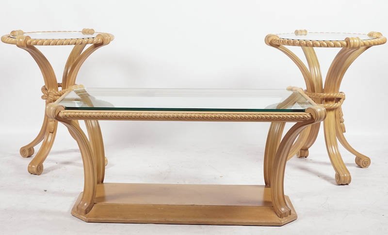 PISTONO, Louis (1888-1976): PISTONO, Louis (1888-1976) Set of sculpted wood with yellow patina two pedestal table and coffee table with volutes and curtain tieback decor. Glass trays. Coffee table : H : 49cm - 19.25" L : 109cm -
