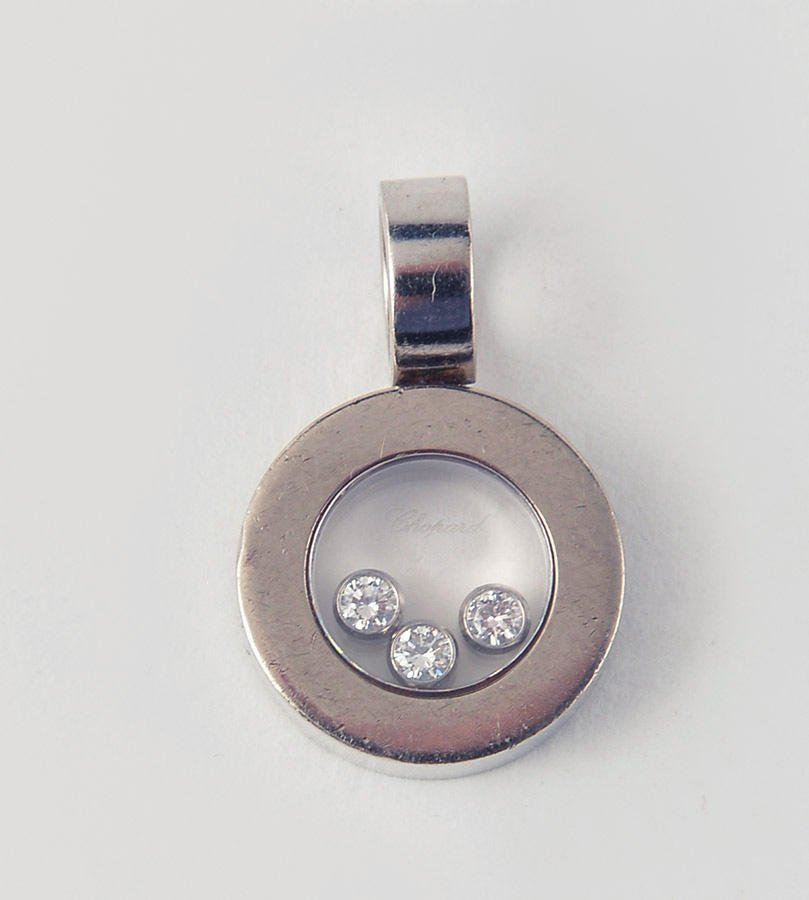 CHOPARD - 18K GOLD AND DIAMONDS: CHOPARD - HAPPY 18K white gold pendent, adorned with three losse diamonds under glass. Weight: 6.9gr .