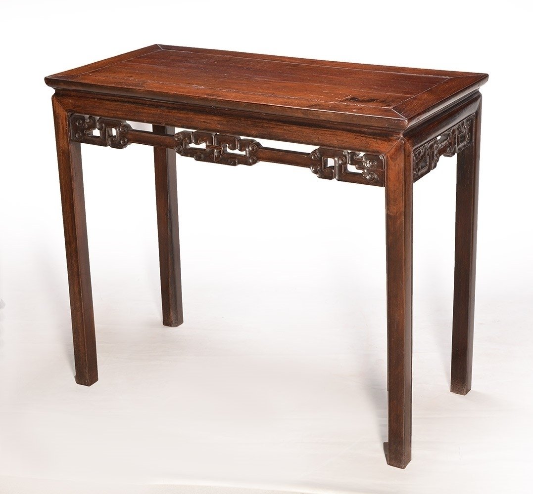 CHINE - 19TH C.: Exotic wood altar table with openworked and sculpted with volute on the belt. China, 19th Century. H : 81cm - 31.75" L : 94cm - 37" l : 47cm - 18.5" Cites permis could be required for this lot.
