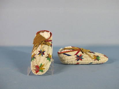 Sioux Fully Beaded Moccasins: Sioux Fully Beaded Moccasins. Solidly beaded soles, multicolored geometric patterns on a white glass beads background. Length: 7". Very good condition. Fully beaded moccasins were given as