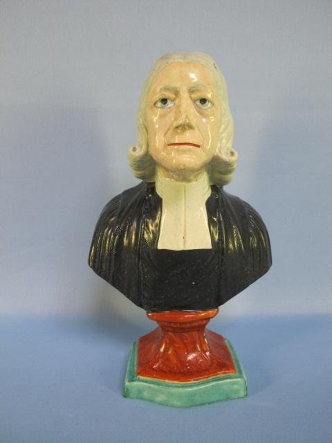 STAFFORDSHIRE BUST OF WESLEY: STAFFORDSHIRE BUST OF WESLEY. English, 19th century. Hand colored bust of the religious leader on a plinth. 10 3/4"Ht. Condition: Numerous air bubbles on painted surface of black garment; firing crack
