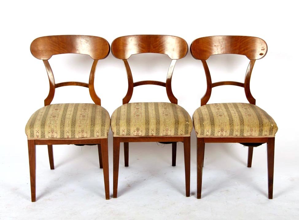 Drei Schaufelstühle, Biedermeier um 1830: Esche. Auf vier leicht geschweiften kantigen Beinen, hufeisenförmiger gepolsterter Sitz, Rückenlehne mit zwei Streben, Abschlußbrett in Schaufelform. H.: 85 cm,Br.: 47 cm, T.: 48 cm.