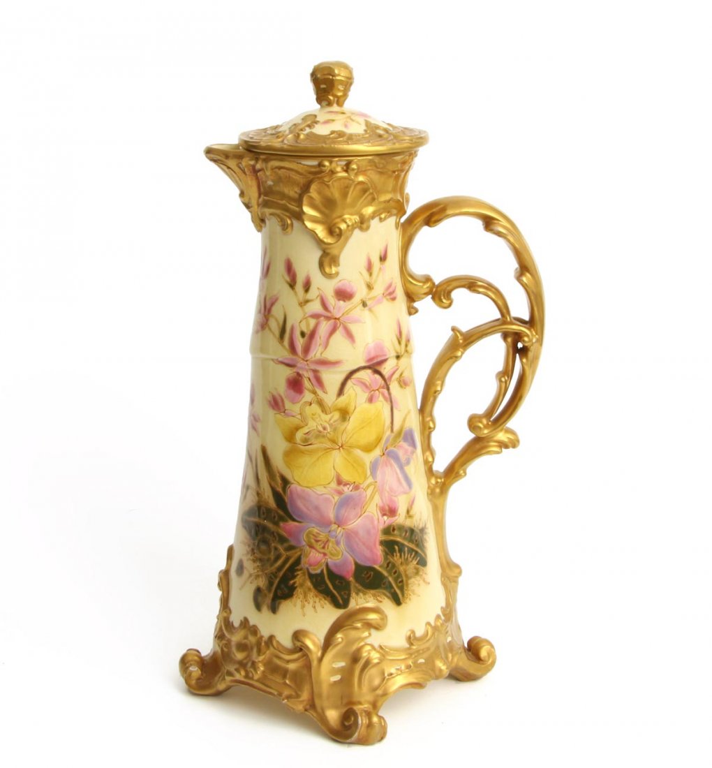 Jugendstil Schenkkanne, Zsolnay, Pécs um 1900: Keramik auf cremefarbenem Fond polychrom mit Orchideenzweigen in zarten Pastellfarben mit feinen goldenen Konturierungen bemalt. Auf vier gerollten Volutenfüßen mit Rocaillenrelief am Fußrand sich 