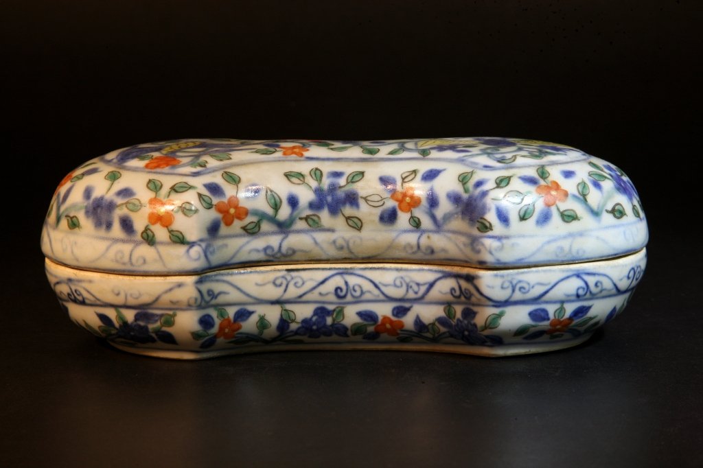 A Wucai Dragon and Phoenix Box: The kidney-shaped body painted in underglaze blue and enamel red, yellow of phoenix and dragon among floral sprays, the bottom section with six-character mark "Da Ming Jia Jing Nien Zhi " L: 9", W: 4.