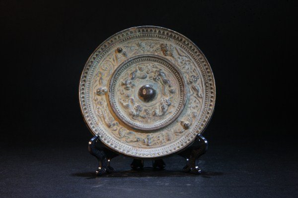 A Bronze Mirror: well-cast bronze mirror, decorated with a group of mystical beasts in the central medallion surrounded by dragons, Eastern Zhou Dynasty Dia.: 5"