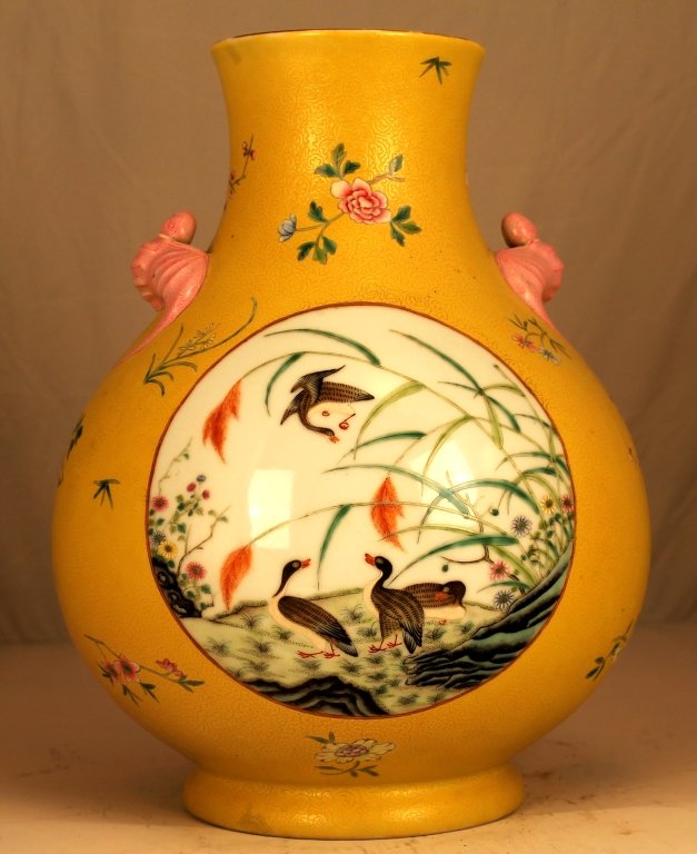 A Yellow-Ground Famille Rose Vase: The pear-shaped body painted in the center medallion with wild ducks in the water-front, all in a yellow glaze ground with floral spray decorations, Qianlong four character mark at base. 19th century 