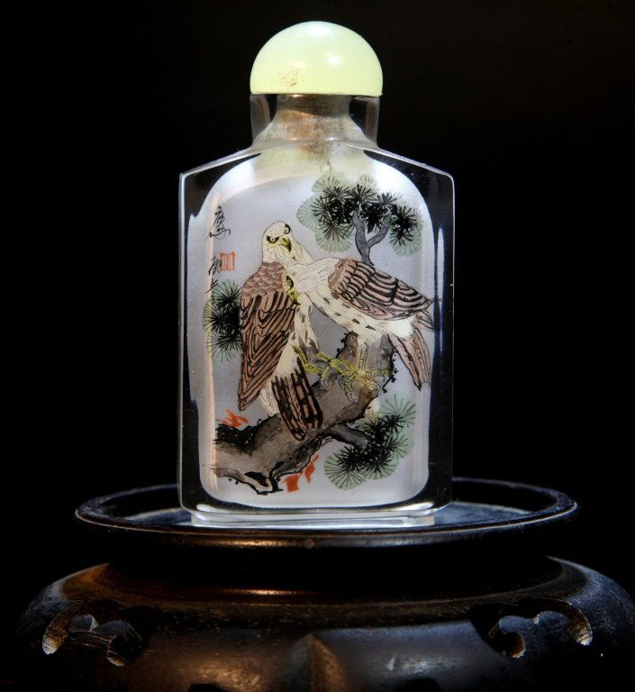 A Reverse Painted Crystal Snuff Bottle: The rock crystal bottle is finely painted with two eagles standing on a pine tree, signed and with artist's seal. Length:0.75, WIdth:1.75, Height:3.5