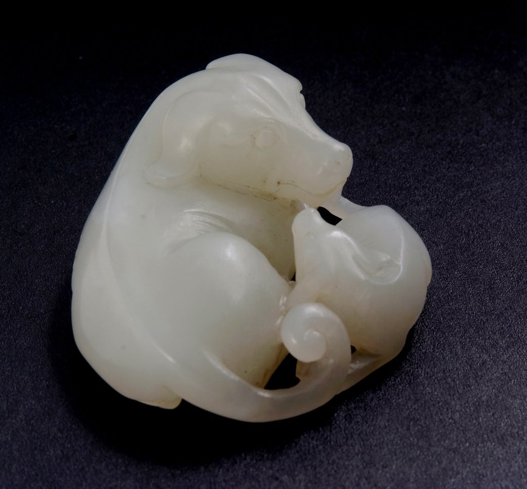 Finely-carved Jade Dog Group,19th Century: The white jade stone carved with a group of recumbent dogs depicting mother and son playing together, comes with its box. Qing Dynasty. Ex-collection from a local collector purchased from New York dur