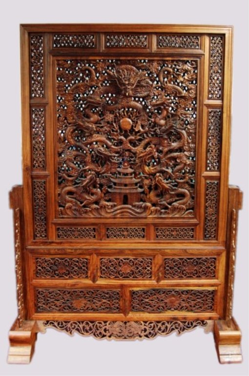 A Large Huanghuali Display Screen: A Large Huanghuali Display Screen and Stand. This finely carved Huanghuali display screen and stand. The screen is carved with nine dragons chasing a flaming pear. The stand carved with detailed flora