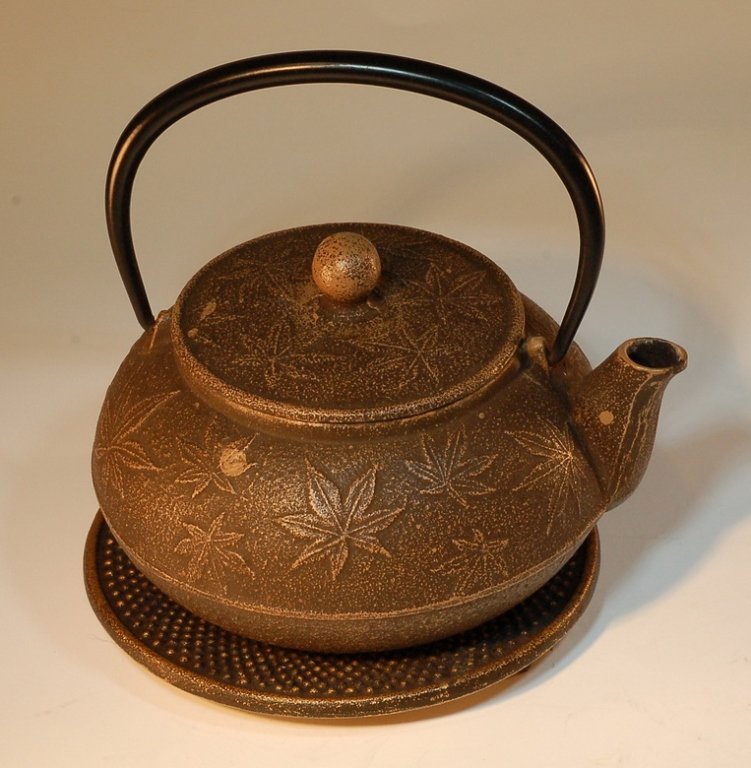 Japanese Iron Teapot with Stand: Japanese Iron Teapot with Stand. Maple Leaf pattern on pot. Size:D6 1/2" H5" Starting Bid: 100