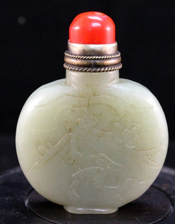 Chinese White Jade Snuff Bottle: Chinese white jade snuff bottle; carved with tree and animal in relief to the front. Red coral stopper with a brass spoon. Size: H2 1/2" W2" Starting Bid: 200
