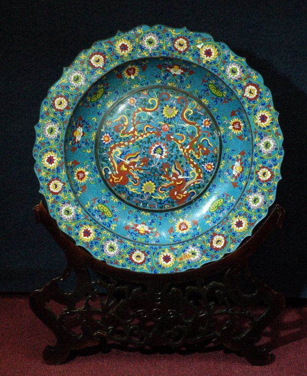 Large Cloisonne Dragon Plate: Extra large cloisonne plate, painted with in the center medallion with two dragons chasing flaming pearl, surrounded with floral sprays boarder. From local Houston collector. Size: D23" H 32" (With st