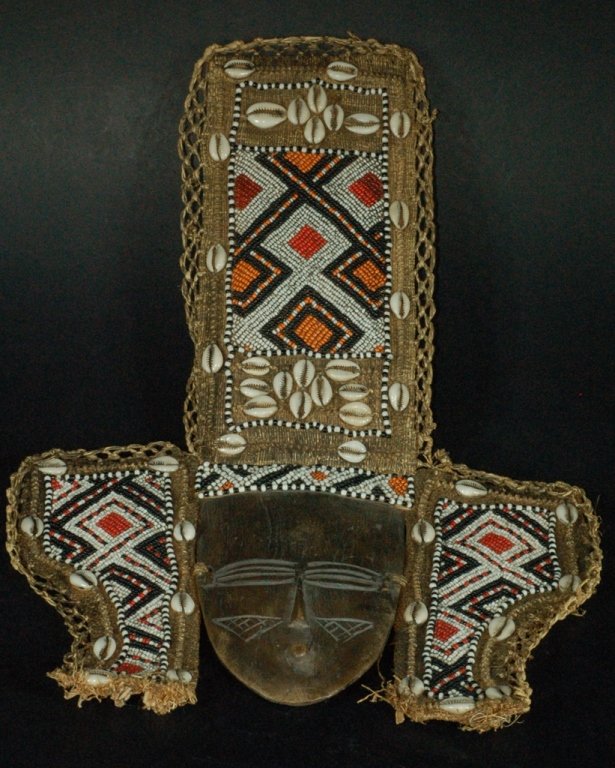 African Carved Wood Mask: African carved wood mask with beaded raffia surround. 18" L x 12" W