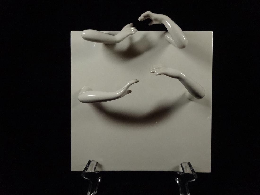 SCULPTURAL CERAMIC TILE, FOUR ARMS AND HANDS EXTENDING: SCULPTURAL CERAMIC TILE, FOUR ARMS AND HANDS EXTENDING FROM SURFACE OF TILE, SIGNED ON VERSO, APPROX 8"H, TILE APPROX 7.5" X 7.5"