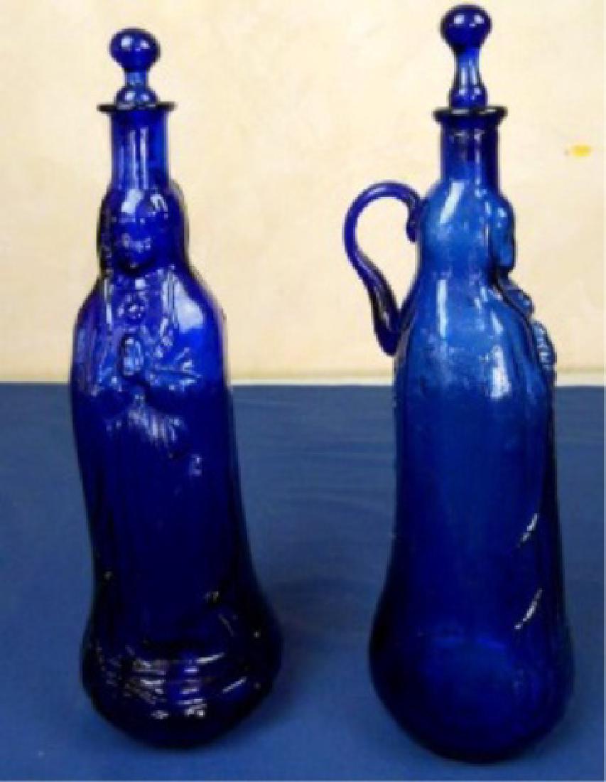 PAIR FRENCH COBALT BLUE GLASS WATER BOTTLES WITH: PAIR FRENCH COBALT BLUE GLASS WATER BOTTLES WITH STOPPERS, EARLY 19TH CENTURY, USED BY LOURDES PILGRIMS TO CARRY WATER, FROM LOURDES, FRANCE, APPROX APPROX 14"H AND 13.5"H
