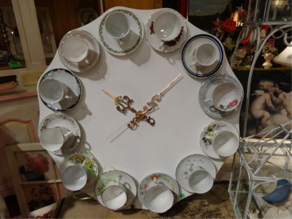 LARGE UMBRA "TEA TIME" TEACUP CLOCK, LIMITED EDITION BY: LARGE UMBRA "TEA TIME" TEACUP CLOCK, LIMITED EDITION BY MATT CART, PORCELAIN TEACUPS AND SAUCER REPLACE NUMERALS, WHITE FINISH WOOD BACK, APPROX 30" DIAMETER