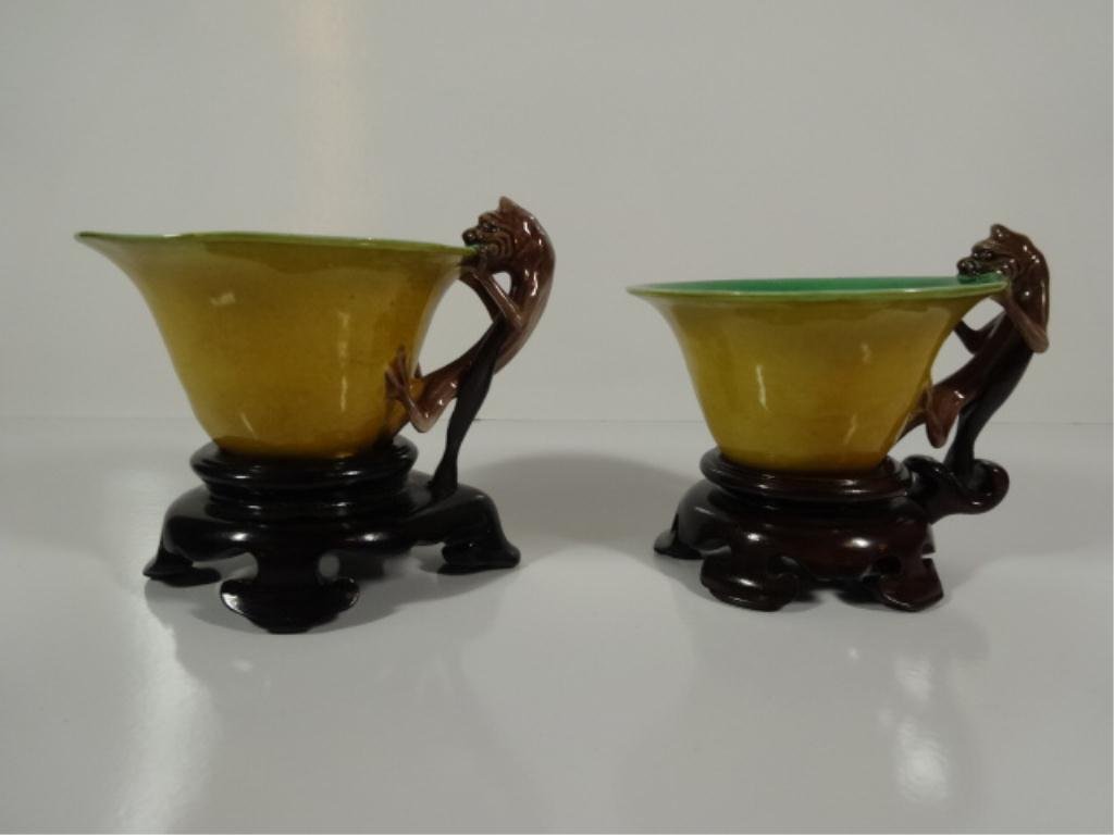 PAIR JAPANESE PORCELAIN SAKE CUPS, LIZARD HANDLES: PAIR JAPANESE GLAZED PORCELAIN SAKE CUPS, HANDLES IN THE FORM OF LIZARDS WITH SPLIT TAILS, WITH CARVED WOODEN STANDS, STORAGE OR DISPLAY BOX INCLUDED, PROVENANCE: FROM THE ESTATE OF ART & ASIAN ANTIQU