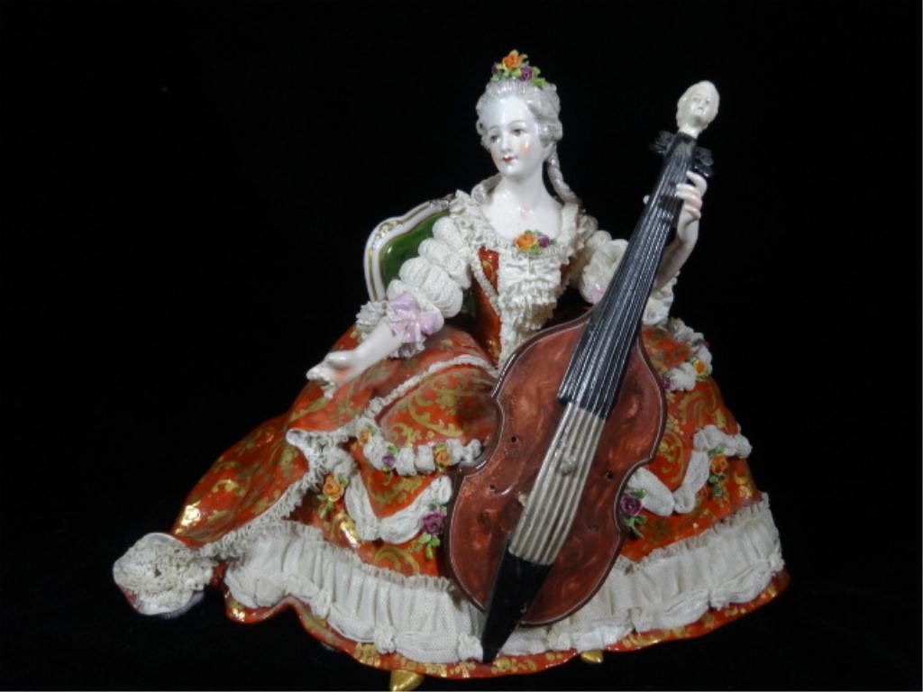 CAPIDOMONTE FIGURINE, WOMAN WITH CELLO, WITH: CAPIDOMONTE FIGURINE, WOMAN WITH CELLO, WITH CAPODIMONTE "N" MARK, ONE FINGER DAMAGED, SOME SMALL CHIPS TO SKIRT, APPROX 9.25"H, SKU460.01
