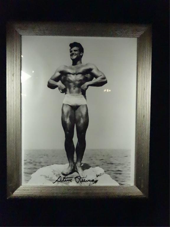 AUTOGRAPHED STEVE REEVES BODY BUILDING PHOTOGRAPH,: AUTOGRAPHED STEVE REEVES BODY BUILDING PHOTOGRAPH, POSING ON ROCK, SIGNED IN MARKER, APPROX 16" X 13" FRAMED