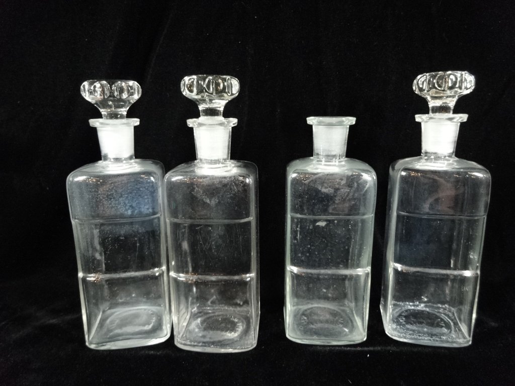 4 PC VINTAGE APOTHECARY JARS WITH 3 STOPPERS, STOPPERS: 4 PC VINTAGE APOTHECARY JARS WITH 3 STOPPERS, STOPPERS HAVE CHIPS TO ENDS, APPROX 9"H