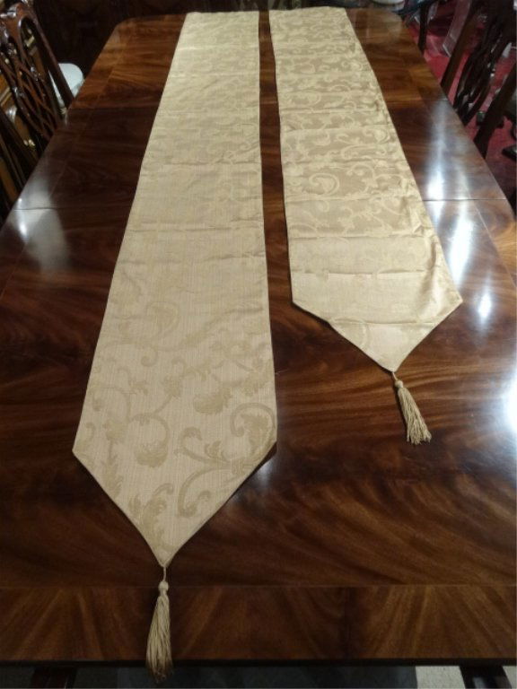 2 GOLD TABLE RUNNERS WITH TASSELS, DIFFERENT LENGTHS,: 2 GOLD TABLE RUNNERS WITH TASSELS, DIFFERENT LENGTHS, ONE MEASURES 102" AND THE OTHER 88"