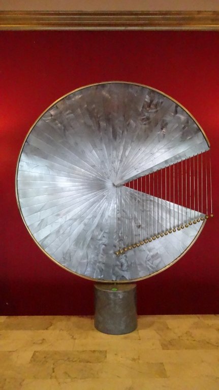 LARGE RARE MID CENTURY CURTIS JERE 1978 SCULPTURE,: LARGE RARE MID CENTURY CURTIS JERE 1978 SCULPTURE, OVERLAPPING SHEETS OF ALUMINUM THAT FORM AN INCOMPLETE CIRCLE OUTLINED IN BRASS, THE NEGATIVE TRIANGULAR SPACE IS ACCENTED BY HANGING BRASS RODS THAT
