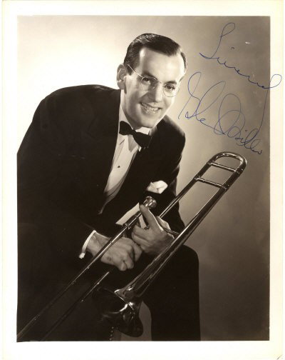 MILLER GLENN: (1904-1944) American Jazz Musician a: MILLER GLENN: (1904-1944) American Jazz Musician and Bandleader. Vintage signed 8 x 10 photograph, an engaging image of Miller standing in a three quarter length pose holding his trombone. Signed in b