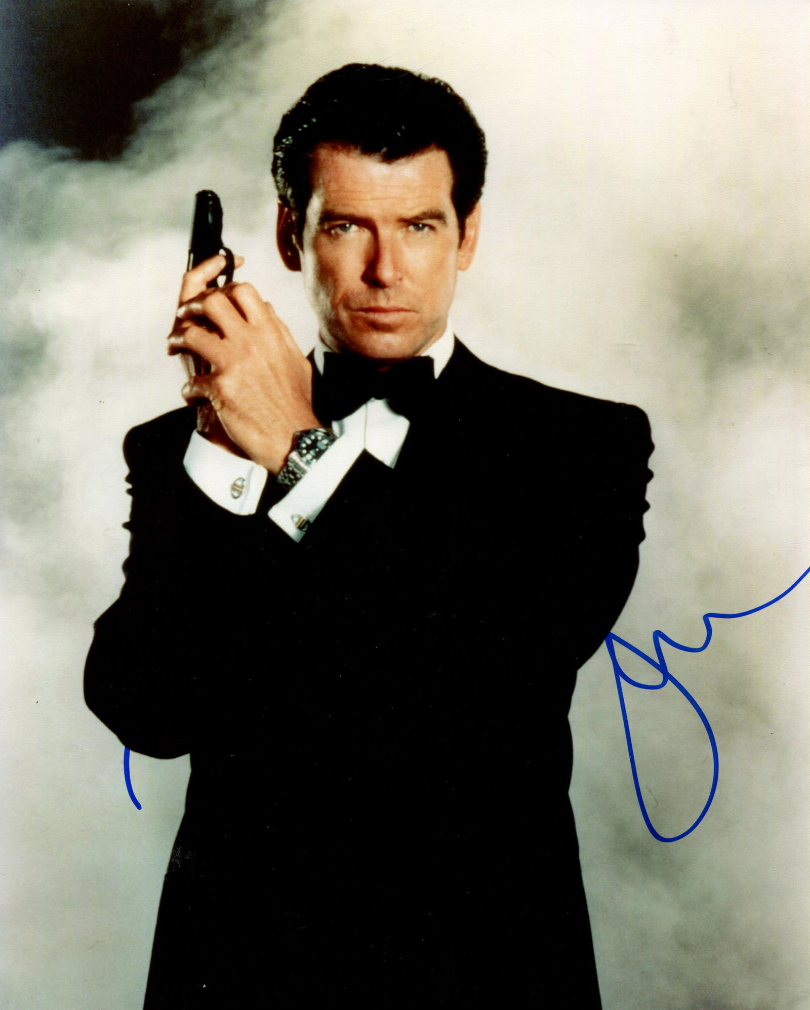BROSNAN PIERCE: (1953- ): BROSNAN PIERCE: (1953- ) Irish actor, famous for his portrayal of the fictional British secret agent James Bond in four films from 1995-2002. Signed colour 8 x 10 photograph of the actor standing in a