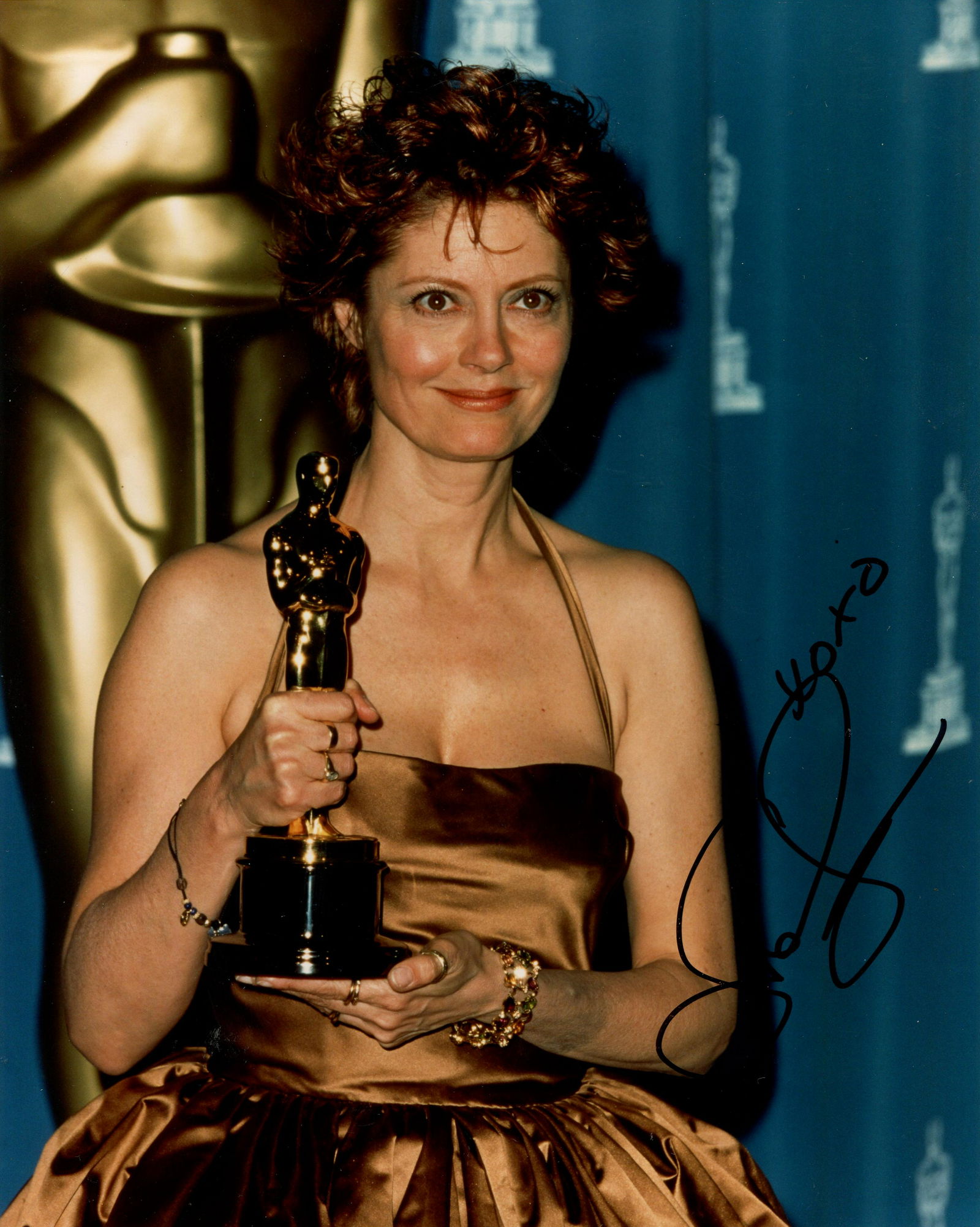 SARANDON SUSAN: (1946- ): SARANDON SUSAN: (1946- ) American actress, Academy Award winner. Signed colour 8 x 10 photograph of Sarandon standing in a half-length pose holding her Oscar statuette in her hands and with a larger m