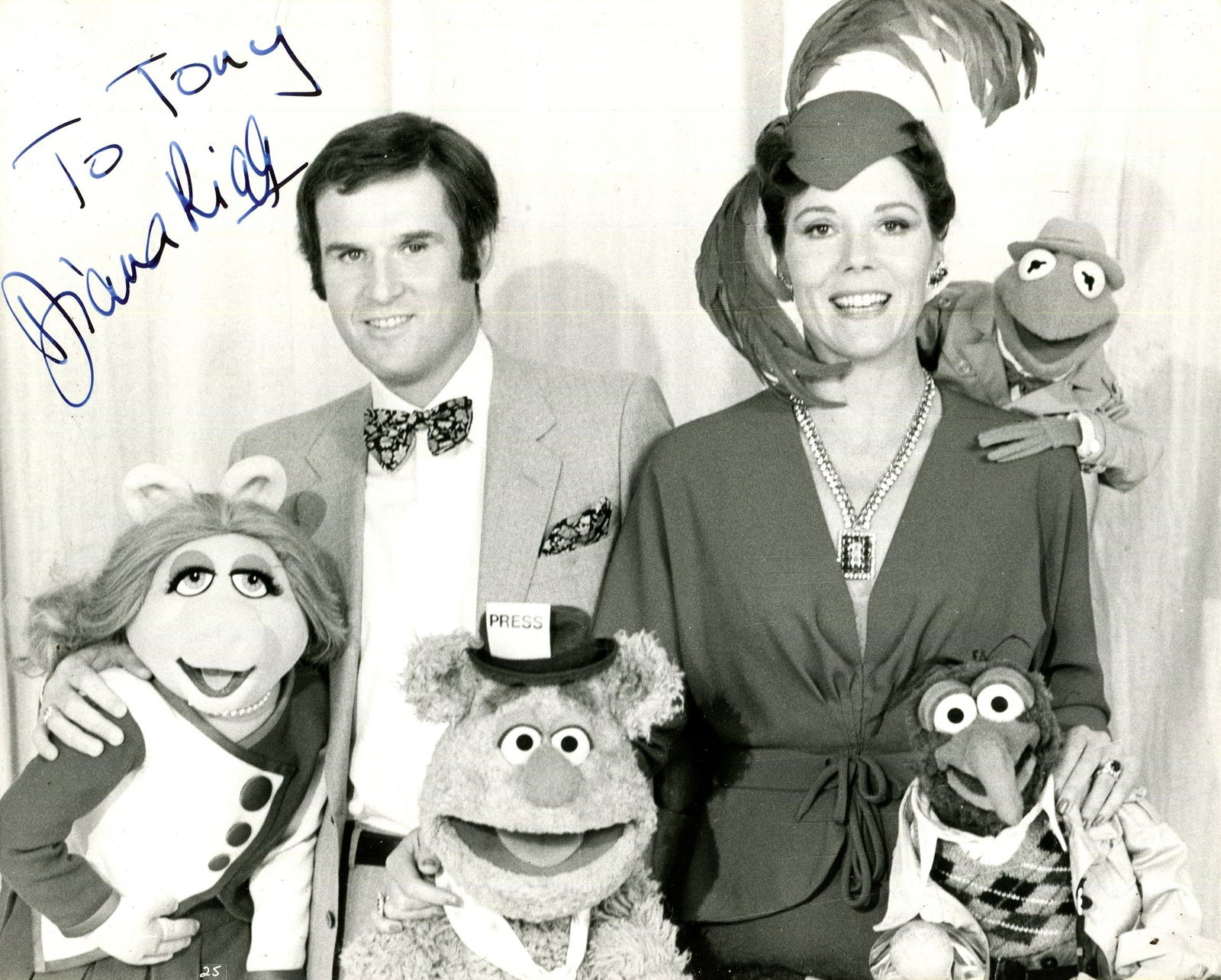 THE MUPPETS: (x2): THE MUPPETS: Diana Rigg (1938-2020) English actress. Signed and inscribed 10 x 8 photograph of Rigg standing in a half-length pose in costume as the famous British fashion designer Lady Holiday, along