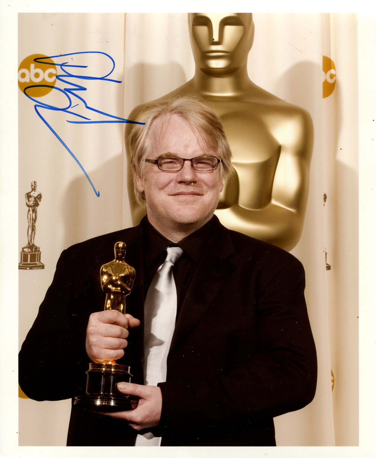 HOFFMAN PHILIP SEYMOUR: (1967-2014): HOFFMAN PHILIP SEYMOUR: (1967-2014) American Actor, Academy Award winner. Signed colour 8 x 10 photograph by Hoffman, the image depicting the actor standing in a half-length pose with his Oscar in han