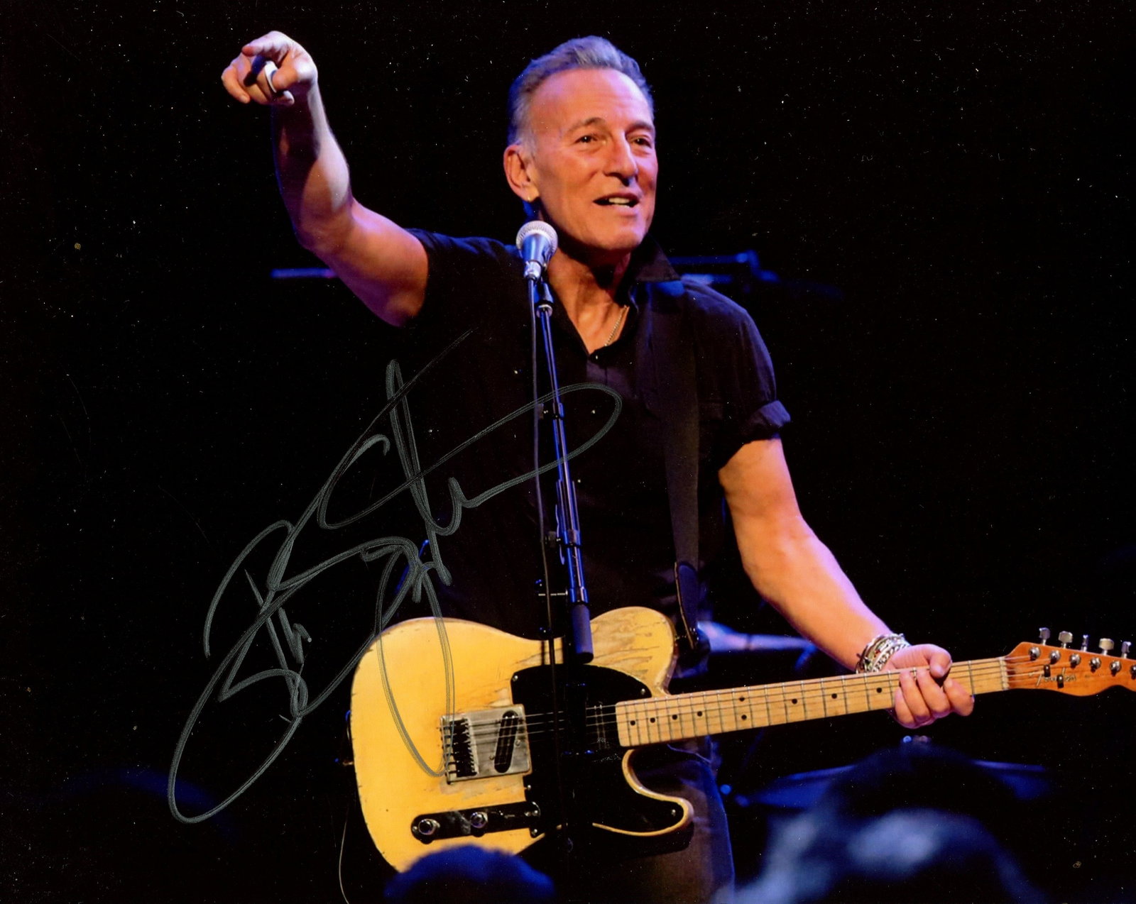 SPRINGSTEEN BRUCE: (1949- ): SPRINGSTEEN BRUCE: (1949- ) American rock singer and guitarist. Signed colour 10 x 8 photograph of Springsteen standing in a half-length pose on a stage, with his guitar. Signed in bold silver ink wit