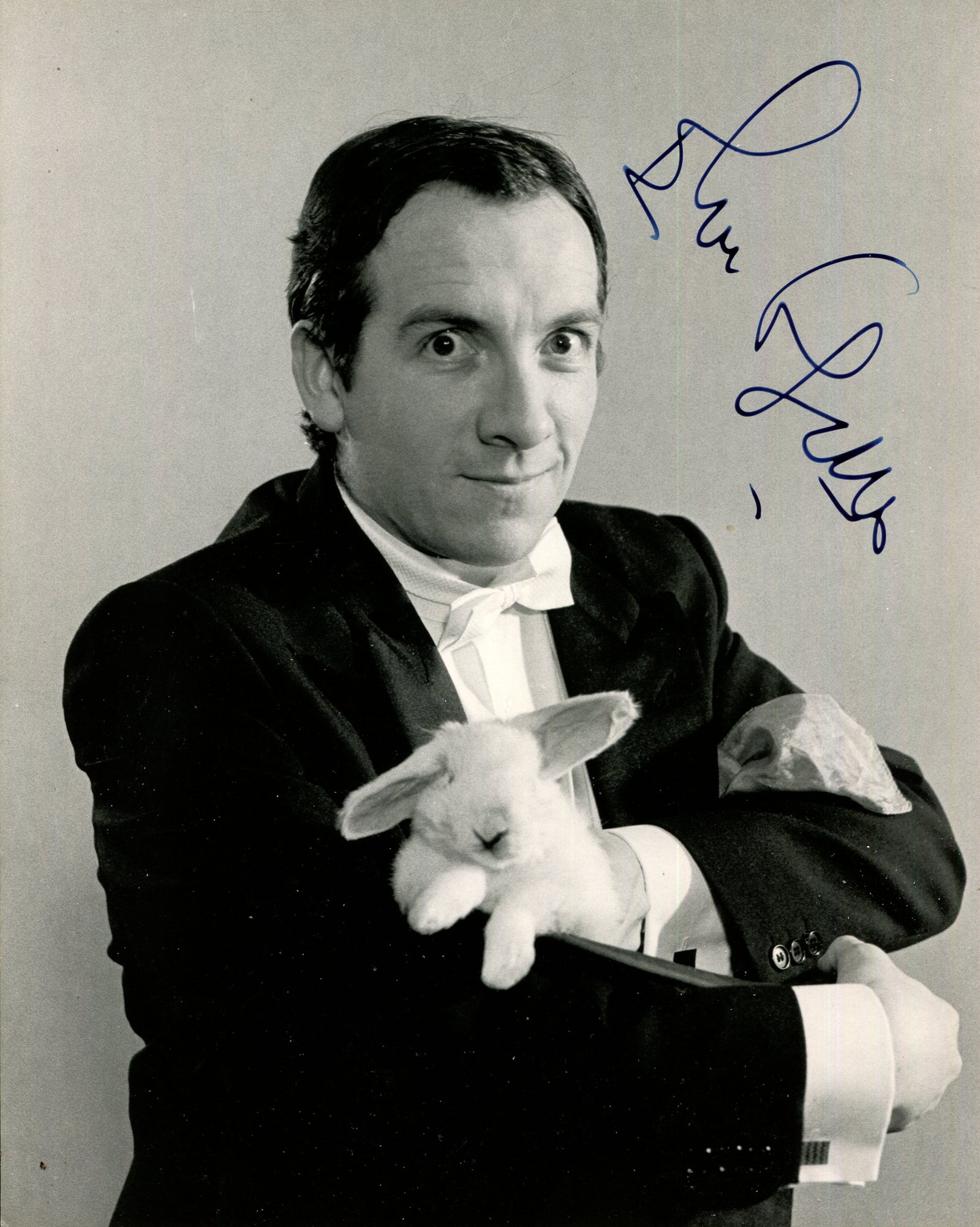 COSTELLO ELVIS: (1954- ): COSTELLO ELVIS: (1954- ) English singer & songwriter. A good signed 8 x 10 photograph, the unusual image depicting Costello standing in a half-length pose, in costume as the inept magician Rosco d