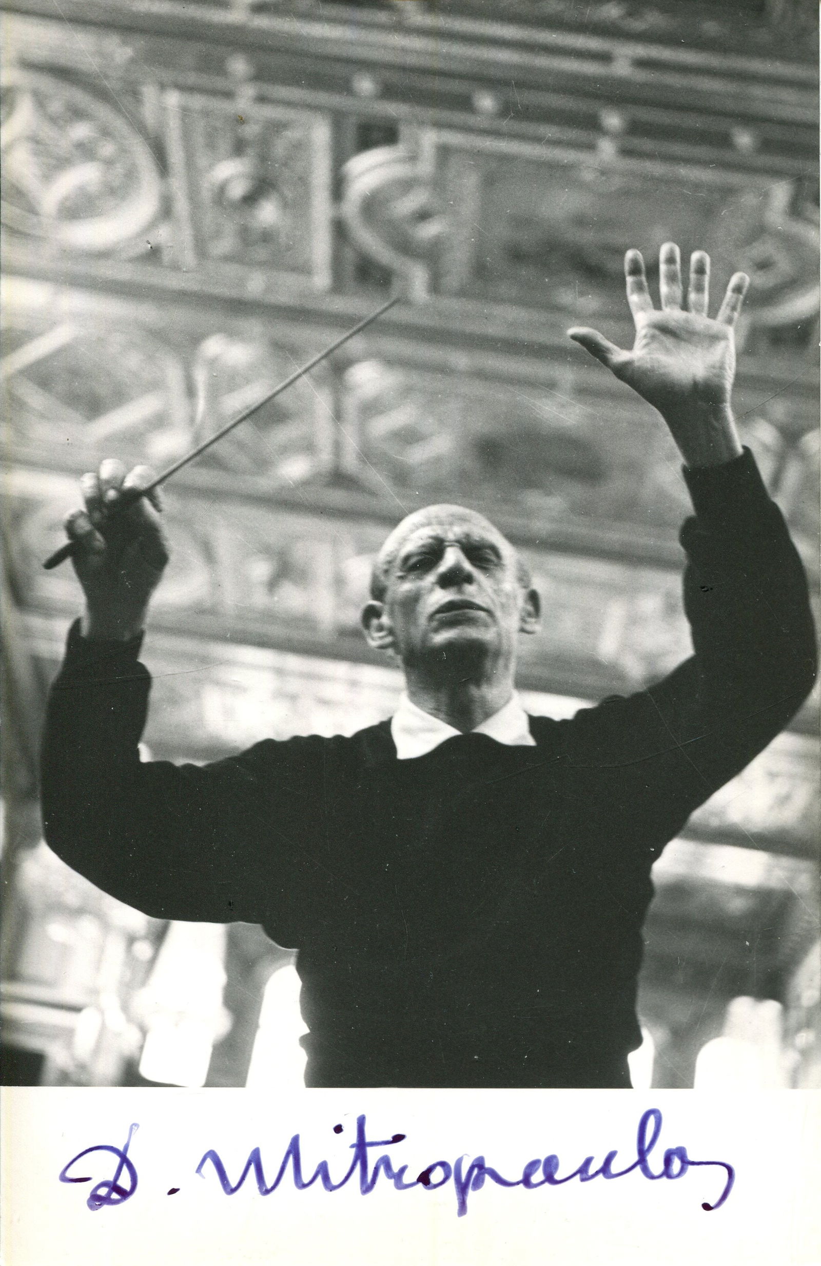 MITROPOULOS DIMITRI: (1896-1960): MITROPOULOS DIMITRI: (1896-1960) Greek-born American conductor, pianist and composer. Signed 3.5 x 5.5 postcard photograph of Mitropoulos standing in a half-length pose conducting with his arms raised
