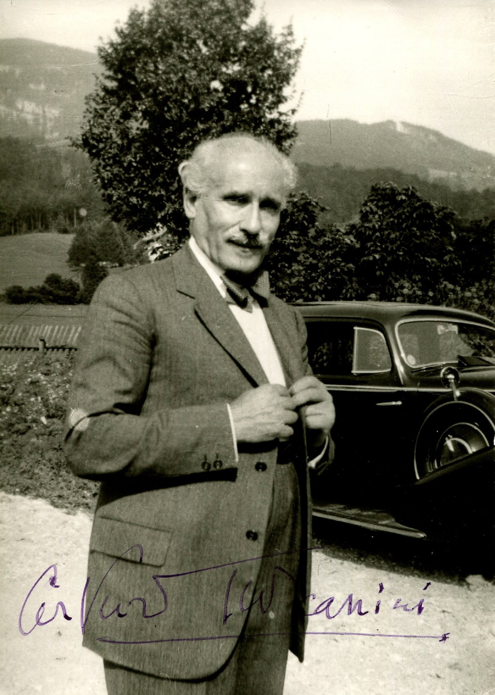 TOSCANINI ARTURO: (1867-1957): TOSCANINI ARTURO: (1867-1957) Italian Conductor. An unusual signed postcard photograph, the Ellinger image from Salzburg depicting Toscanini outdoors, standing in a three-quarter length pose. Signed