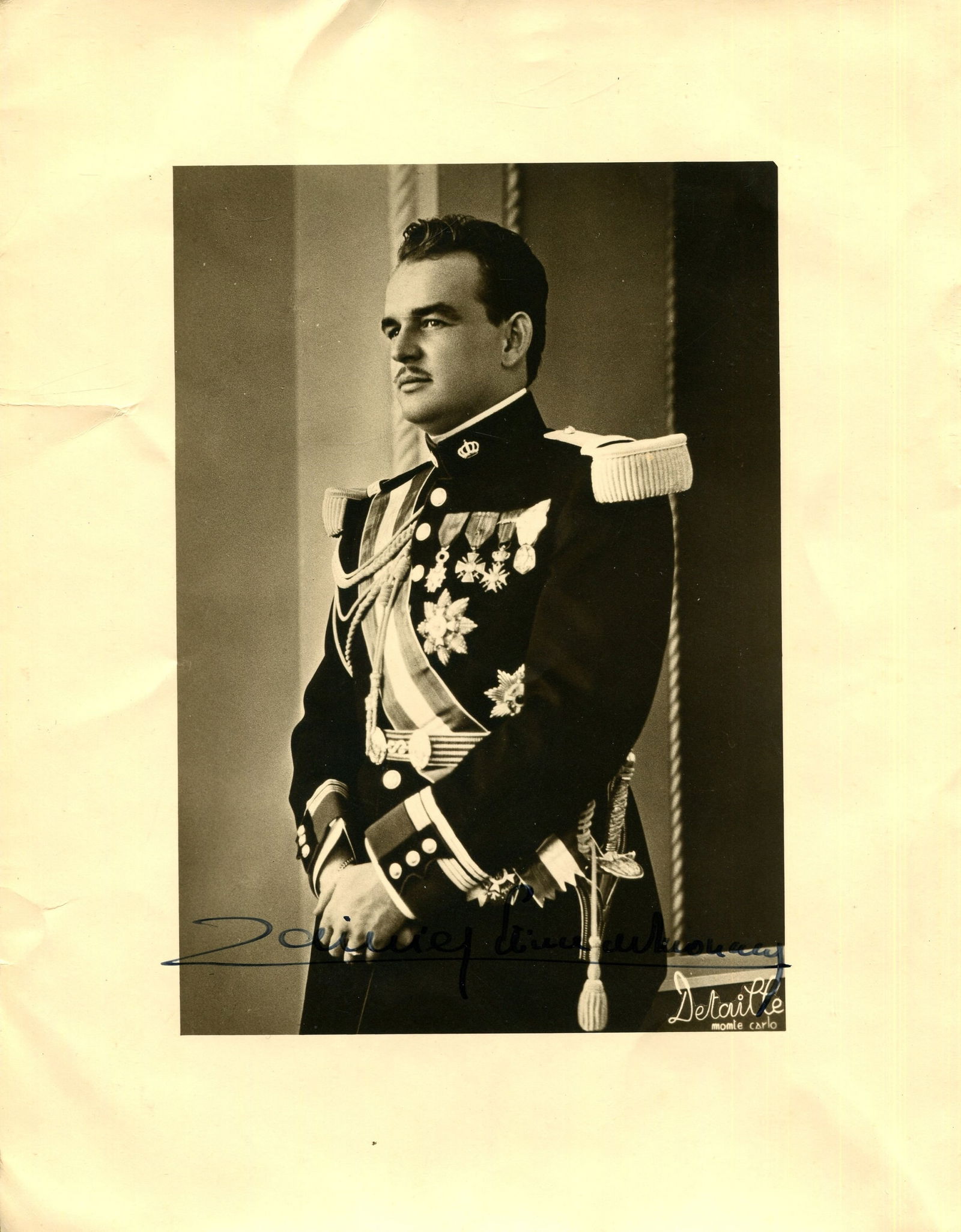 RAINIER III: (1923-2005): RAINIER III: (1923-2005) Prince of Monaco 1949-2005. Vintage signed 7 x 9 photograph of the young, handsome Prince standing in a formal three-quarter length pose wearing the ceremonial military dress