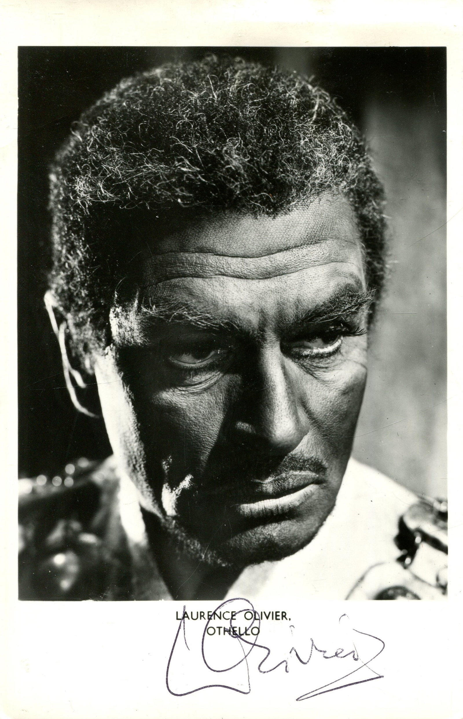 OLIVIER LAURENCE: (1907-1989): OLIVIER LAURENCE: (1907-1989) English actor, Academy Award winner. Attractive signed 3.5 x 5.5 postcard photograph by Olivier, the image depicting the English awarded actor in costume, in a head and