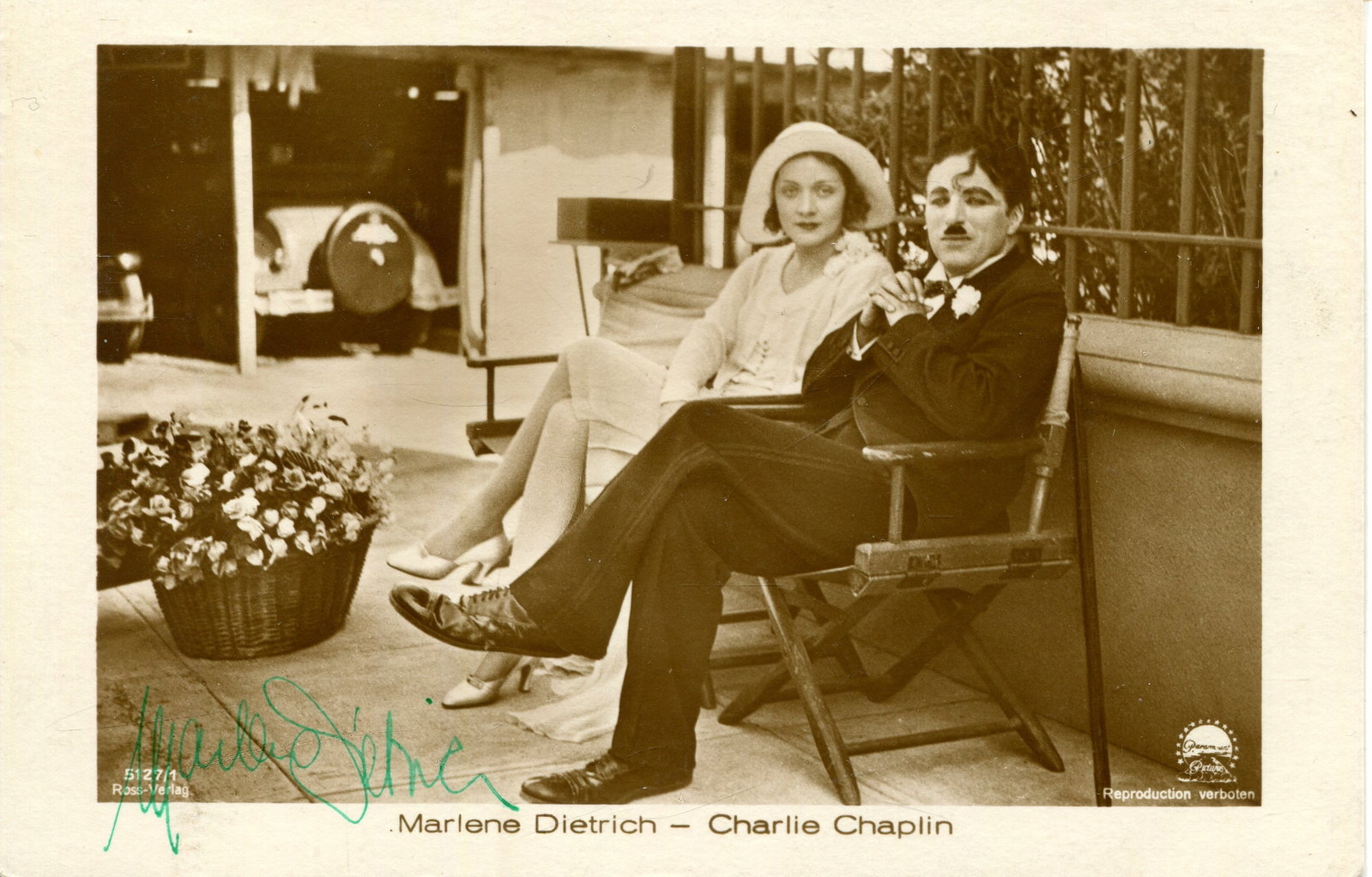 DIETRICH MARLENE: (1901-1992): DIETRICH MARLENE: (1901-1992) German-born American actress and singer. A good vintage signed sepia postcard photograph of Dietrich seated outdoors in a full-length pose, alongside film comedy actor