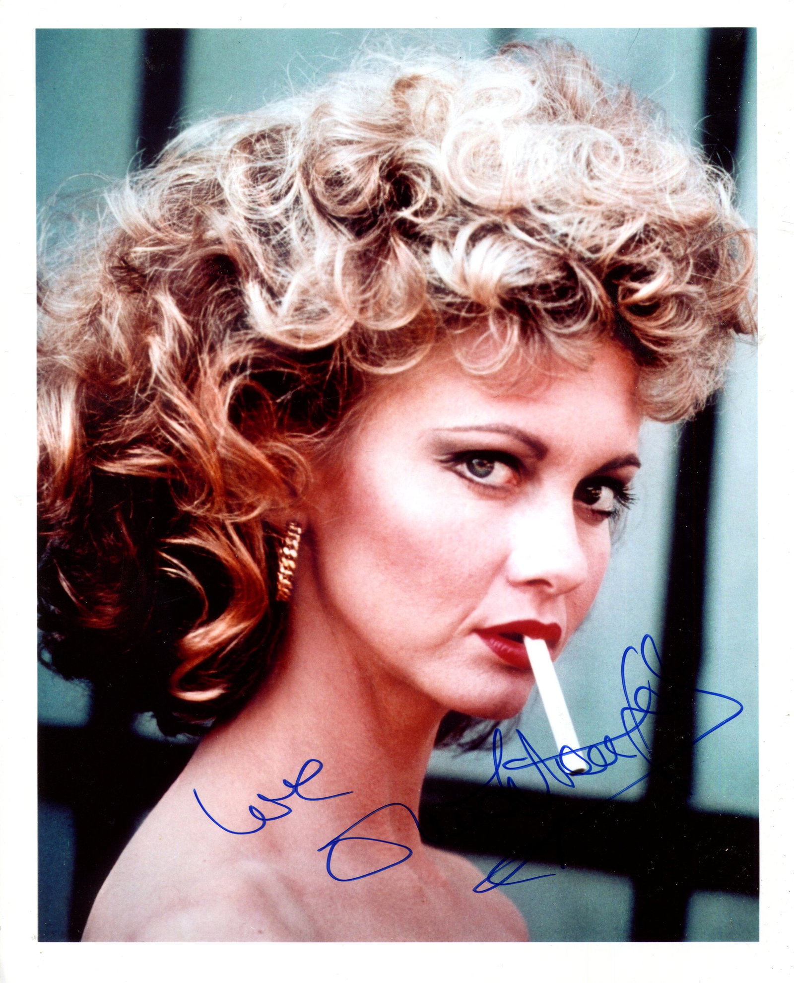 NEWTON-JOHN OLIVIA: (1948-2022): NEWTON-JOHN OLIVIA: (1948-2022) British-Australian actress and singer. Attractive signed colour 8 x 10 photograph of Newton-John in a close-up portrait pose, smoking a cigarette, in costume as Sandy