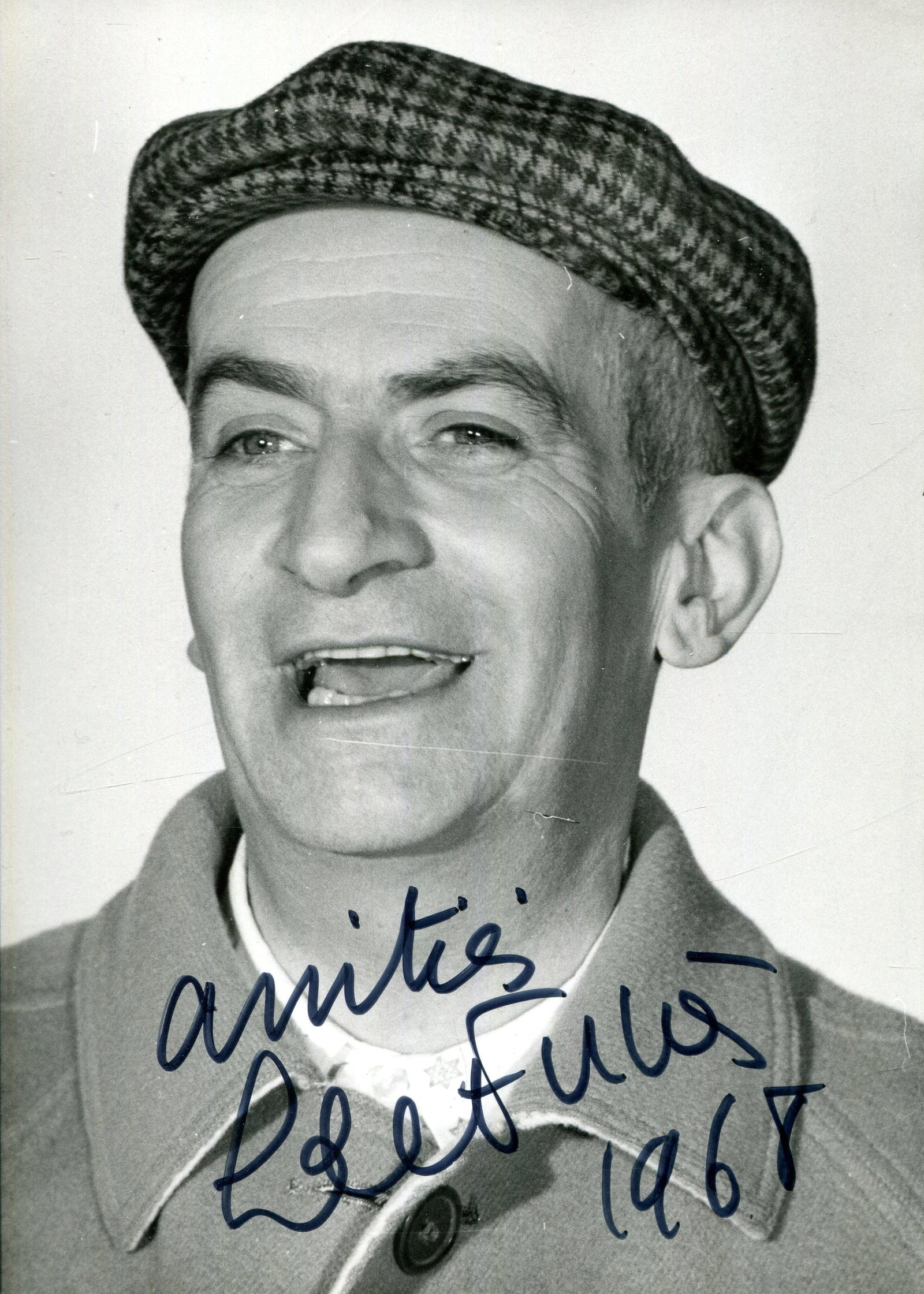 DE FUNÈS LOUIS: (1914-1983): DE FUNÈS LOUIS: (1914-1983) French actor and comedian. Vintage signed 3.5 x 5 photograph of the actor in a head and shoulders wearing a checked flat cap. Signed in black ink to a lighter area at