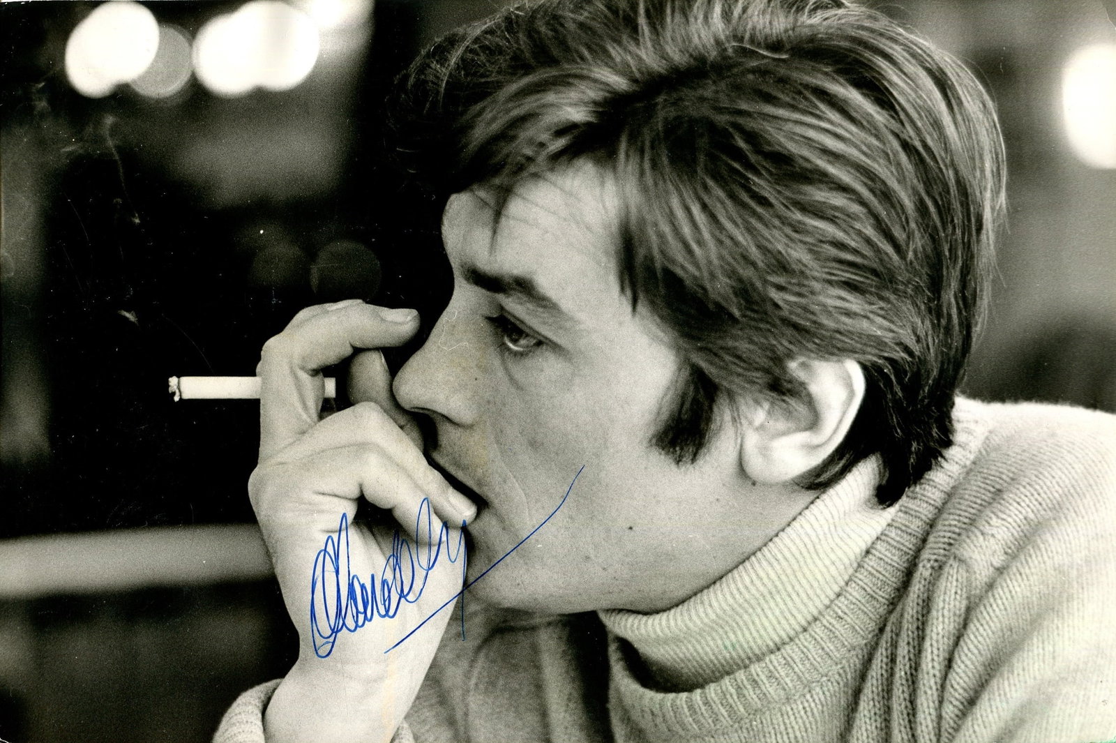 DELON ALAIN: (1935-2024): DELON ALAIN: (1935-2024) French actor. A good signed 9.5 x 6.5 photograph of Delon, the unusual image depicting the young French actor in a thoughtfull head and shoulders pose, smoking a cigarette.