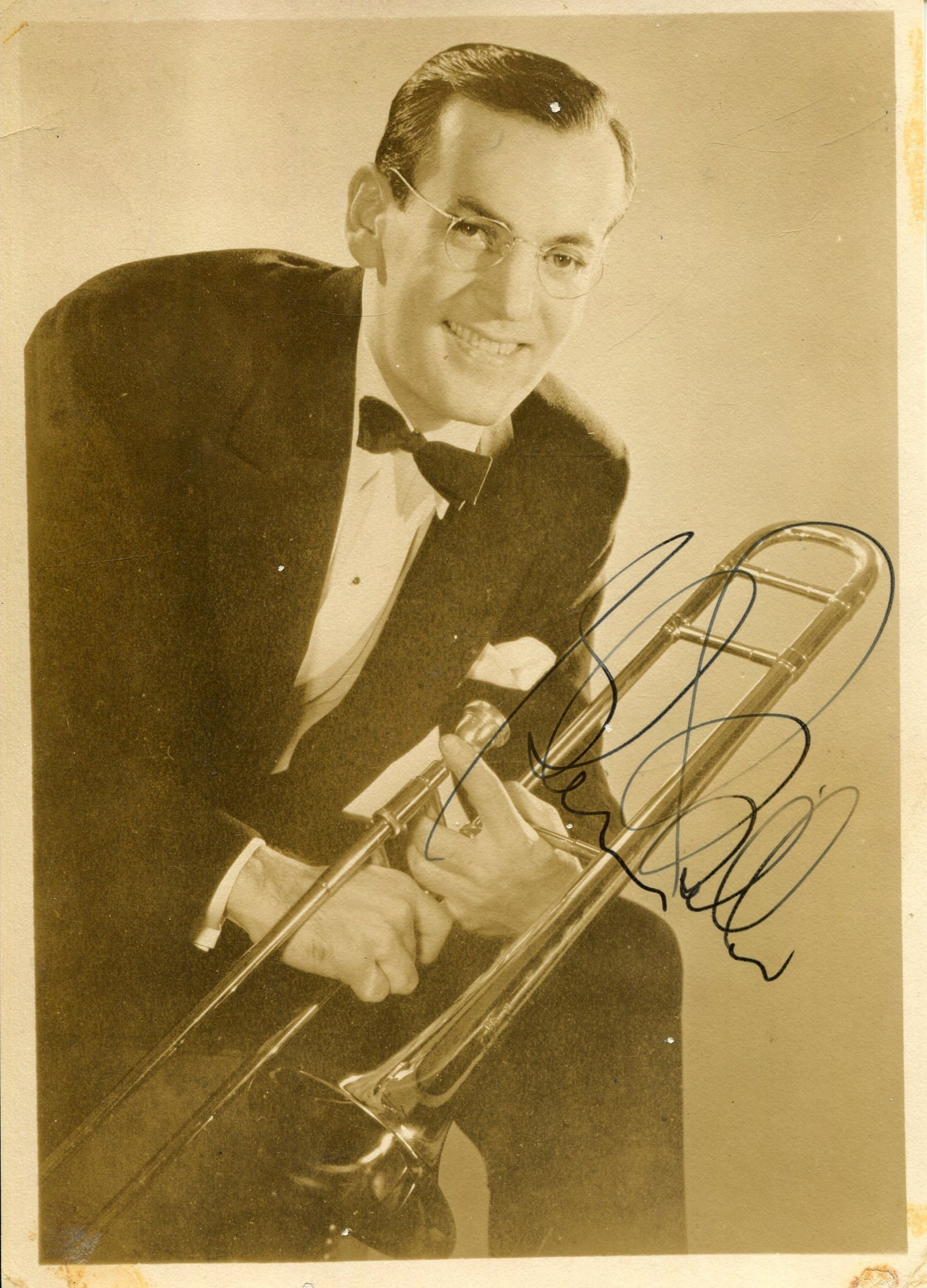 MILLER GLENN: (1904-1944): MILLER GLENN: (1904-1944) American big band trombonist and bandleader. Vintage signed 5 x 7 photograph of Miller in a three-quarter length pose holding his trombone in his hands. Signed in black