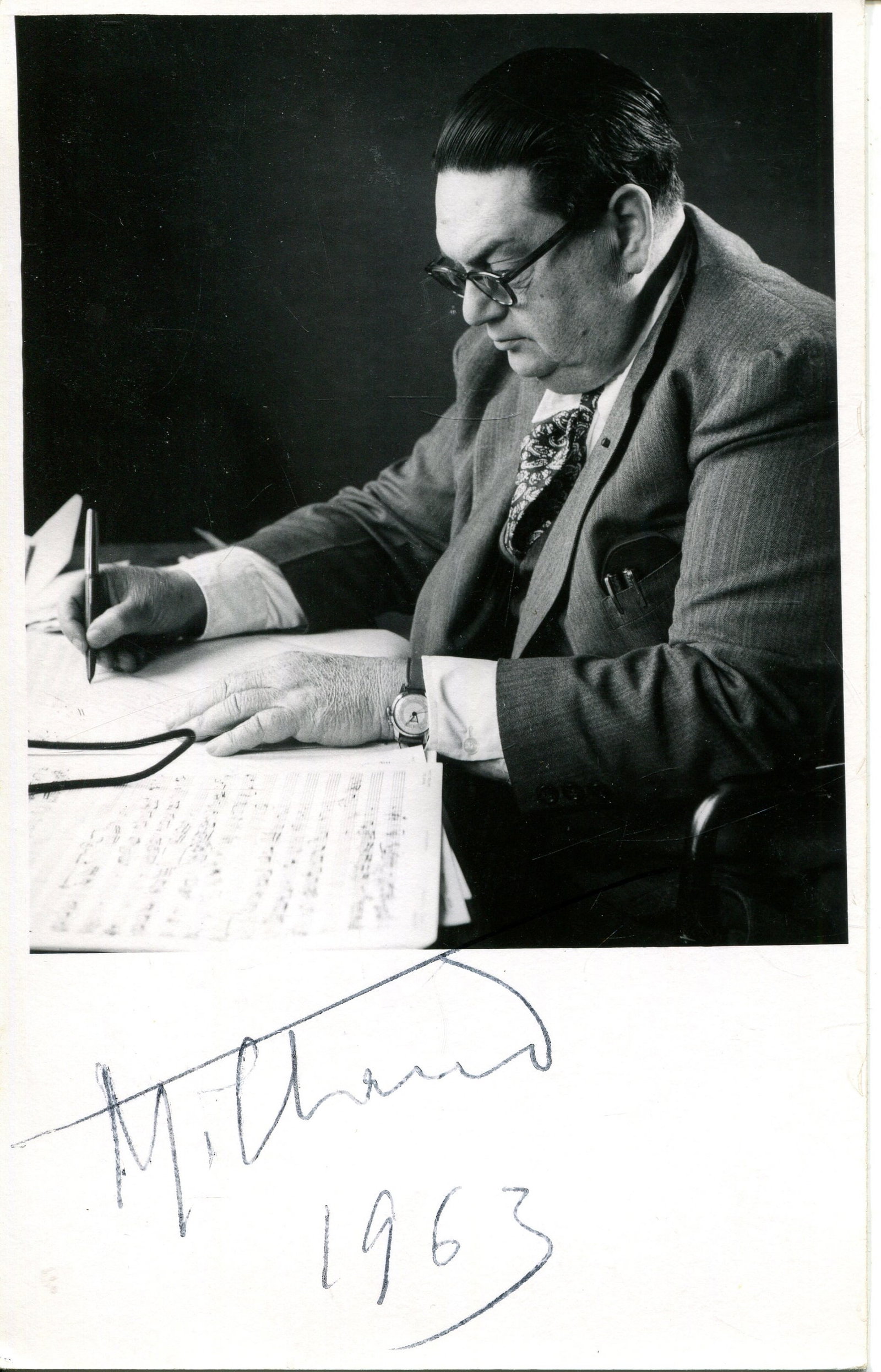 MILHAUD DARIUS: (1892-1974): MILHAUD DARIUS: (1892-1974) French Composer. Signed postcard photograph, the image showing Milhaud seated in half-length pose working on a musical score. Signed `Milhaud´ in black ink to the